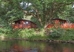 a house on a hill next to a river at Ogwen Bank Caravan And Lodge Park in Bethesda