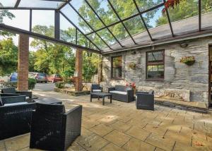 a patio with furniture and a stone building with a glass roof at Ogwen Bank Caravan And Lodge Park in Bethesda