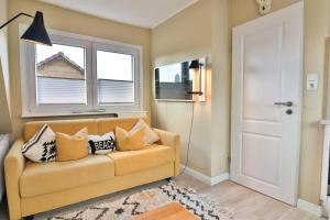 un salon avec un canapé et deux fenêtres dans l'établissement Langeooger Viermaster - Gelbes Segel, à Langeoog