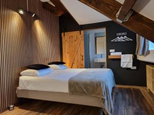 a bedroom with a bed and a wooden wall at B&B Barvaux, Durbuy in Durbuy