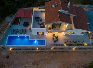 eine Luftansicht eines Hauses mit Pool in der Unterkunft Vila Tramonto in Pinezici
