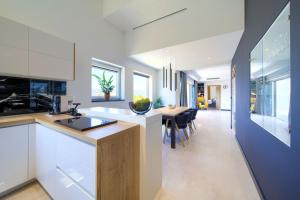 a kitchen with white cabinets and a dining table at Vila Tramonto in Pinezici