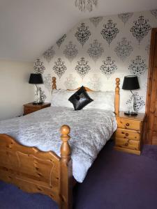 a bedroom with a wooden bed with two lamps and a wall at Eden House in Carlingford