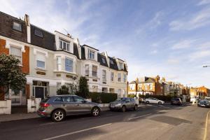 une rue avec des voitures garées sur le côté de la route dans l'établissement The London Crib - Relaxing 1BDR Flat with Terrace, à Londres