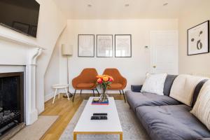 - un salon avec un canapé et une cheminée dans l'établissement The London Crib - Relaxing 1BDR Flat with Terrace, à Londres