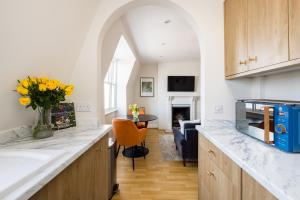 - une cuisine avec un comptoir orné d'un vase de fleurs dans l'établissement The London Crib - Relaxing 1BDR Flat with Terrace, à Londres