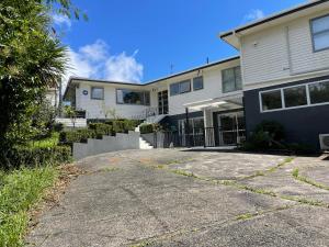 an empty driveway in front of a house at family friendly 3BR flat - 3min walk to the beach - self contained in Auckland
