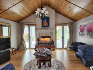 een woonkamer met een open haard en een houten plafond bij Bruntwoodlodge in Cambridge