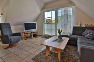 uma sala de estar com um sofá e uma televisão em Kiek rin bi Kati - Ferienwohnung 4 em Langeoog
