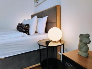 1 dormitorio con 1 cama y 1 mesa con lámpara en S15 Studio Apartment FREE PARKING en Zagreb