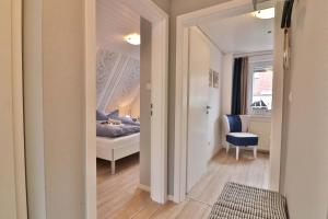 Habitación con dormitorio con cama y ventana en Kiek rin bi Kati - Ferienwohnung 2 en Langeoog