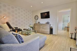 a living room with a couch and a tv on a wall at Kiek rin bi Kati - Ferienwohnung 1 in Langeoog