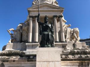 a statue of a woman holding a flag on a monument at Laniakea Suites in Lisbon