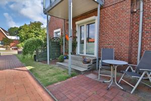 una casa con una mesa y sillas en un porche en Kiek rin bi Kati - Ferienwohnung 1 en Langeoog