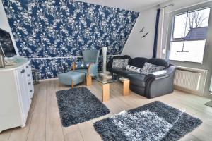 ein Wohnzimmer mit blauen und weißen Blumentapeten in der Unterkunft Kiek rin bi Kati - Ferienwohnung 3 in Langeoog