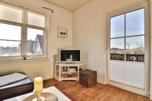a living room with a tv and two windows at Killewipps EG in Langeoog