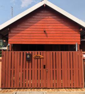 a red barn with a large wooden door at ChillHouse24 @ DonMueang in Ban Don Muang