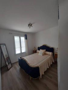 a bedroom with a blue bed and a window at A tribord: maison chaleureuse à 5min de la plage in La Cotinière
