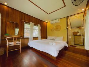 a bedroom with a white bed and a chair at Mangrove bungalow & restaurant in Ko Kood