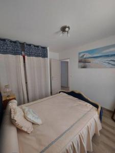 een slaapkamer met een bed en een schilderij aan de muur bij A tribord: maison chaleureuse à 5min de la plage in La Cotinière
