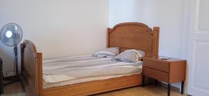 uma cama com uma cabeceira de madeira ao lado de uma cómoda em VIP Appartment Centre Payerne em Payerne