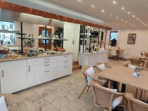 翁特拉梅尔高Gästehaus u Ferienwohnungen Veronika incl Frühstücksbuffet und KönigsCard mit 200 kostenlosen Attraktionen的配有桌椅的厨房和餐厅
