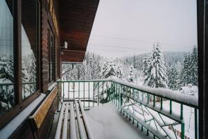 a balcony with a view of a snow covered forest at Chata Franka in Donovaly