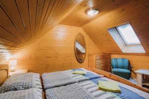 a attic bedroom with two beds and a mirror at Chata Franka in Donovaly