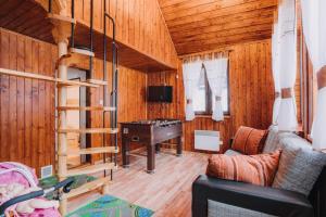 a living room with a staircase and a desk at Chata Franka in Donovaly