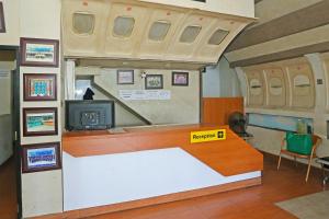 um quarto com uma secretária numa sala de comboios em SUPER OYO 92003 Sky Airlines Guesthouse em Tangerang