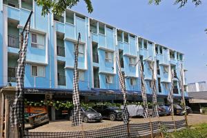um edifício azul com carros estacionados num parque de estacionamento em SUPER OYO 92003 Sky Airlines Guesthouse em Tangerang
