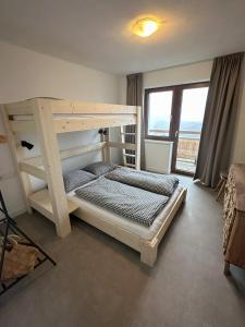 a bedroom with a bunk bed and a large window at Hotel Der Drahtesel in Bramberg am Wildkogel