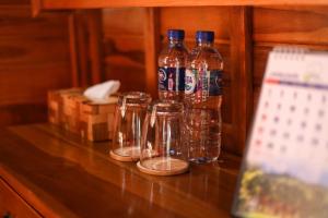 three bottles of water sitting on a wooden table at The Polumb Garden Bedugul in Tabanan