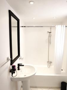 a white bathroom with a sink and a mirror at MERÁKI VILLA & APARTMENTS in Vamos
