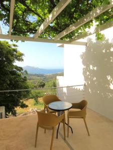 una mesa y sillas en un patio con vistas en MERÁKI VILLA & APARTMENTS en Vamos