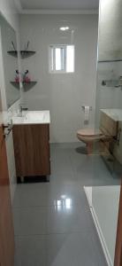 uma casa de banho branca com um lavatório e um WC em Apartamento Alba no Portonovo