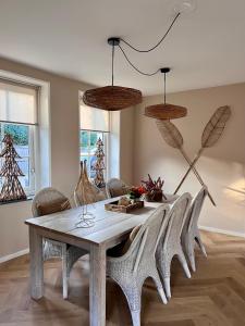 uma sala de jantar com uma mesa de madeira e cadeiras em De Kroft Beach Residences Noordwijk aan Zee em Noordwijk