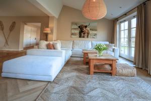 a living room with a white couch and a table at De Kroft Beach Residences Noordwijk aan Zee in Noordwijk