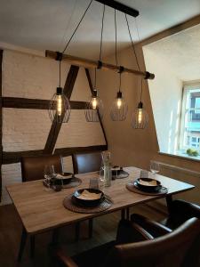 une salle à manger avec une table en bois et des lumières dans l'établissement Unterm Walmdach No. 3, à Dinkelsbühl
