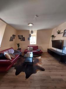 a living room with red couches and a tv at Unterm Walmdach No. 3 in Dinkelsbühl