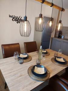 a dining room table with plates and glasses and lights at Unterm Walmdach No. 3 in Dinkelsbühl