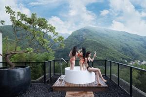 Tres chicas sentadas en una bañera en la cima de una montaña en Deer Chaser, en Lugu