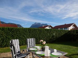 einen Tisch mit Platten und Blumen sowie zwei Stühlen in der Unterkunft Astara - Dein Traum-Ferienhaus in Schwangau in Schwangau