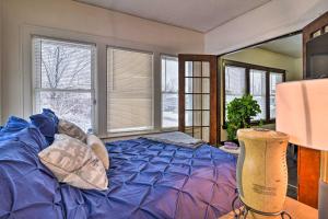 a bedroom with a blue bed and windows at Awesome Detroit Apartment Less Than 3 Mi to Midtown! in Detroit