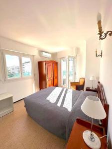 ein Schlafzimmer mit einem Bett und einem Tisch mit einer Lampe in der Unterkunft Viva Riviera Large 1 Bedroom with Sunny Terrace in Cannes