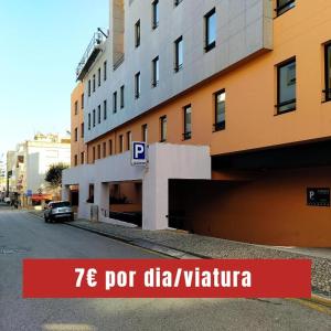 un bâtiment sur le côté d'une rue avec un garage dans l'établissement EXE Wellington, à Figueira da Foz