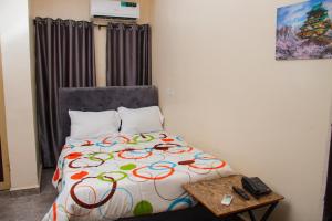 Schlafzimmer mit einem Bett und einem Tisch mit einem Telefon in der Unterkunft Go2Hotel45 in Lagos