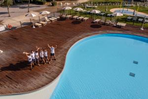a group of people standing next to a swimming pool at Club del Sole Rimini Family Resort in Rimini
