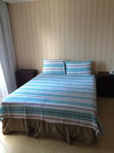 1 dormitorio con 1 cama con sábanas azules y blancas en Flat na Berrini, en São Paulo