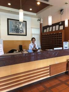 a woman sitting at a counter in a restaurant at Tonwa Resort Hotel in Khon Kaen